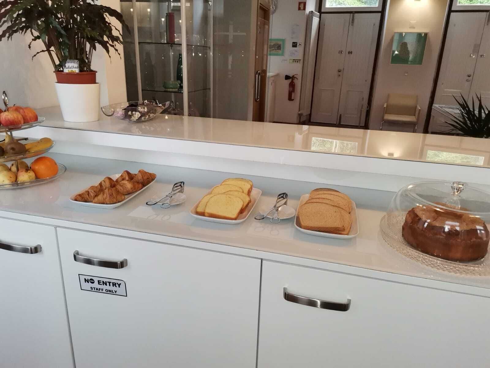 A breakfast buffet with croissants, bread, and pastries.