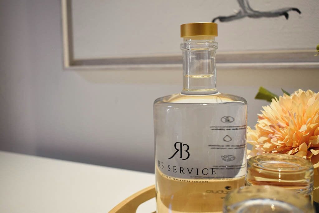 Eine mit "R3 SERVICE" beschriftete Flasche auf einem Tablett mit Blumen.