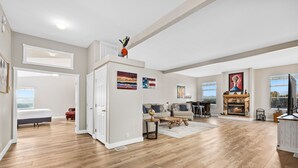 A spacious living room with hardwood flooring, a fireplace, and a dining area with a view. - 30+ Night Stay! Beautiful Property - Spa, Views, LRG Patio! (Temecula)