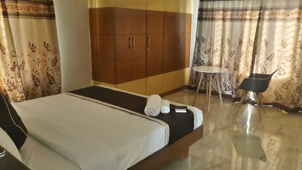 Une chambre d’hôtel avec un lit, une armoire, une petite table et une chaise.
