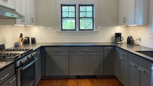 A modern kitchen with grey cabinets, a built-in oven, a gas stove, and a window above the sink. - Inviting, Cozy Catskills Home - Primed for Fall! (Shandaken)