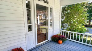 A porch with a white door, a lantern, and two potted plants. - The Downing House - Newly Updated 4bd Farmhouse! (York)