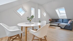 A modern loft apartment with a dining area, a sofa, and skylights. - TotalApartments - Vervet Studio Apartments (Tromsø)