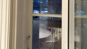 A view through a window at night, featuring a building with multiple floors and a snowy ground. - TotalApartments - Vervet Studio Apartments (Tromsø)