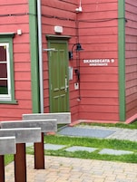 Un edificio rojo con puerta verde y un letrero que dice "SKANSEGATA 9 APARTMENTS".