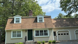 A two-story house with a brick chimney, a front porch, and a garage. - Ogunquit -2 Bedroom Family Condo with POOL 2 week stay (Ogunquit)