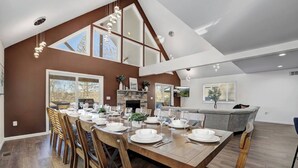 Un comedor amplio con una larga mesa de madera dispuesta para seis personas, flanqueada por sillas de madera.