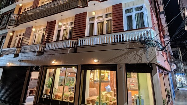 A multi-story hotel with balconies, large windows, and a ground-floor shop. - Hotel Triratna (Kathmandu)