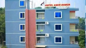 Un immeuble abritant un hôtel à plusieurs étages, sur lequel on peut lire l’inscription « HÔTEL AMIR HAMZA ».
