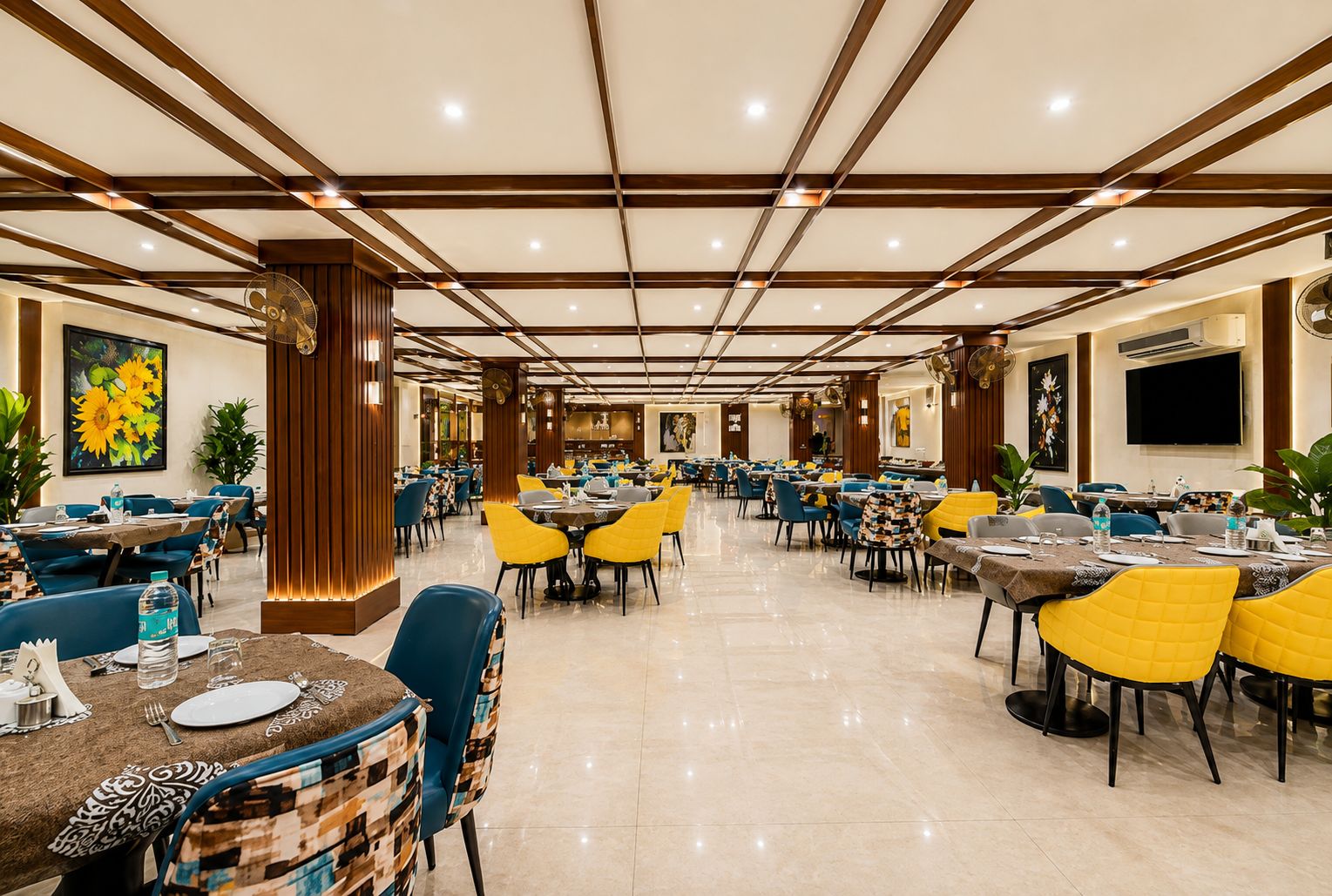 A spacious dining area with multiple tables and chairs, a polished floor, and a modern ceiling design.