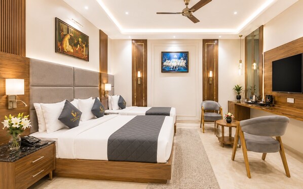 A hotel room with a bed, bedside tables, a desk, a chair, a TV, and artwork on the walls.