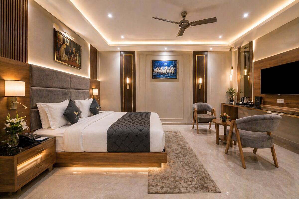 A modern bedroom with a bed, bedside tables, a desk, a chair, a TV, and a ceiling fan.