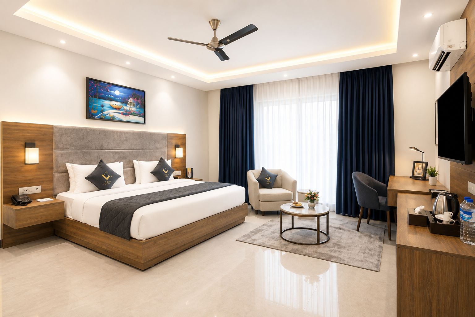 Une chambre d’hôtel moderne équipée d’un grand lit, d’un bureau, d’une chaise, d’un ventilateur de plafond et d’une télévision.