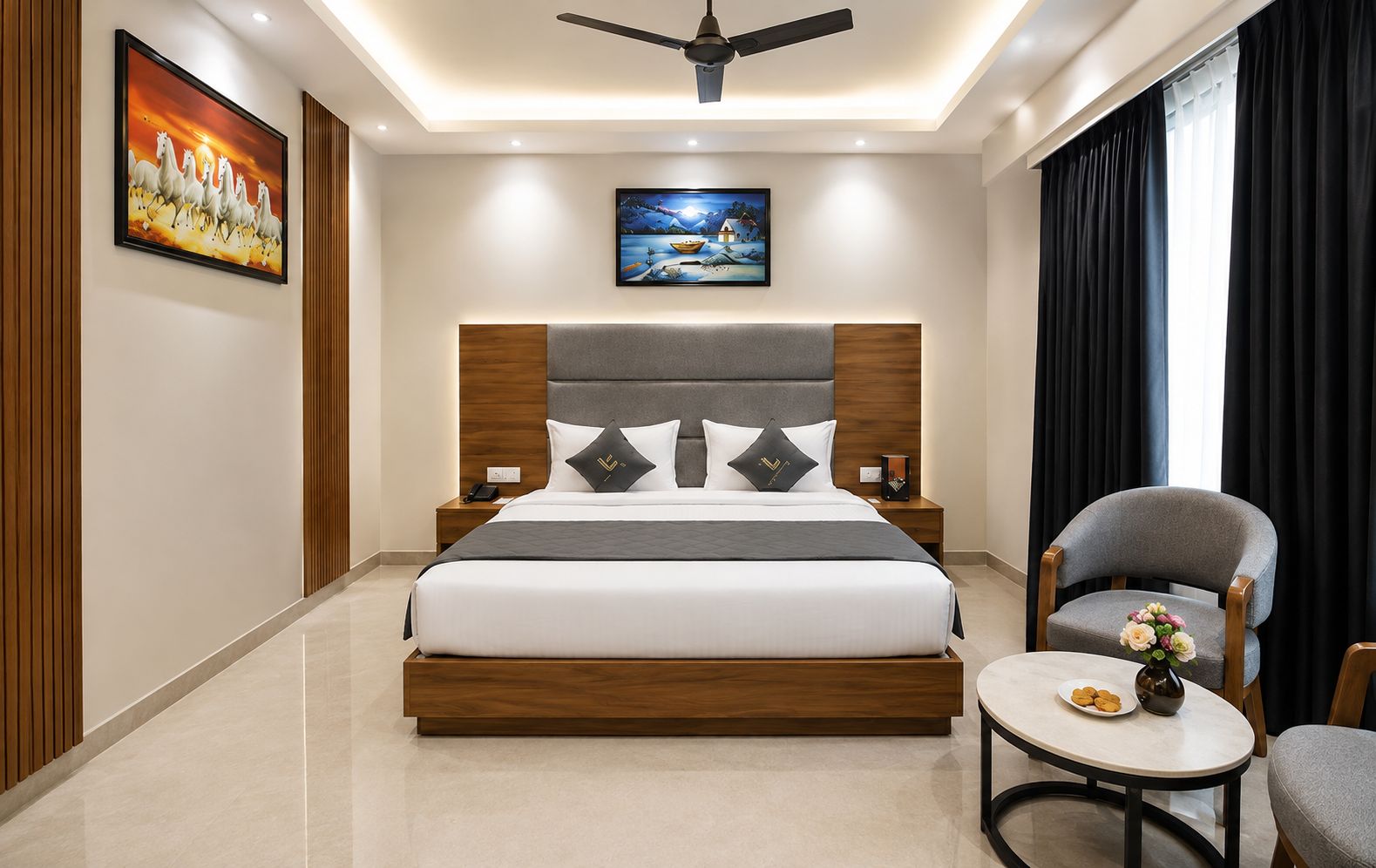 Ein modernes Hotelzimmer mit einem großen Bett, einem Deckenventilator, Kunstwerken an den Wänden und Blick ins Freie.