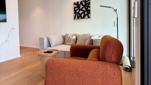 A modern living room with a sofa, a coffee table, and a floor lamp. - Beautiful apartment in historic Wangen im Allgäu (Wangen im Allgäu)