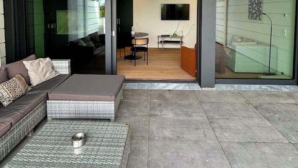 A modern living room with a sofa, a coffee table, and a dining area with a table and chairs. - Beautiful apartment in historic Wangen im Allgäu (Wangen im Allgäu)