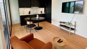 A modern living room with a sofa, a coffee table, and a TV mounted on the wall. - Beautiful apartment in historic Wangen im Allgäu (Wangen im Allgäu)