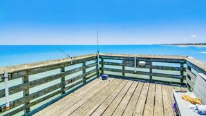 A wooden pier with a railing, a fishing rod, and a bench. - Charming 1-bedroom condo in welcoming Isle of Palms with AC, WiFi (Isle of Palms)