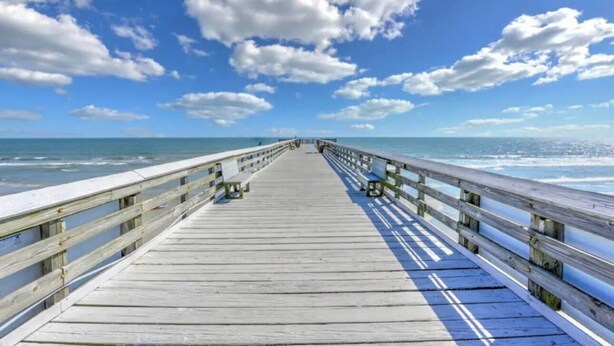 A wooden pier extending into the ocean with benches and railings. - Charming 1-bedroom condo in welcoming Isle of Palms with AC, WiFi (Isle of Palms)