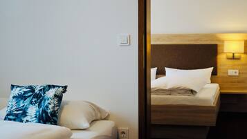 Una habitación de hotel con una cama, una mesita de noche y un enchufe.