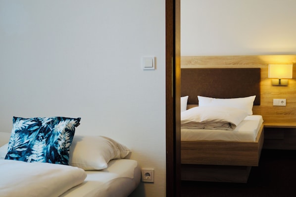 A hotel room with a bed, a nightstand, and a wall socket. - Hotel & Restaurant Pelikan (Beuron)