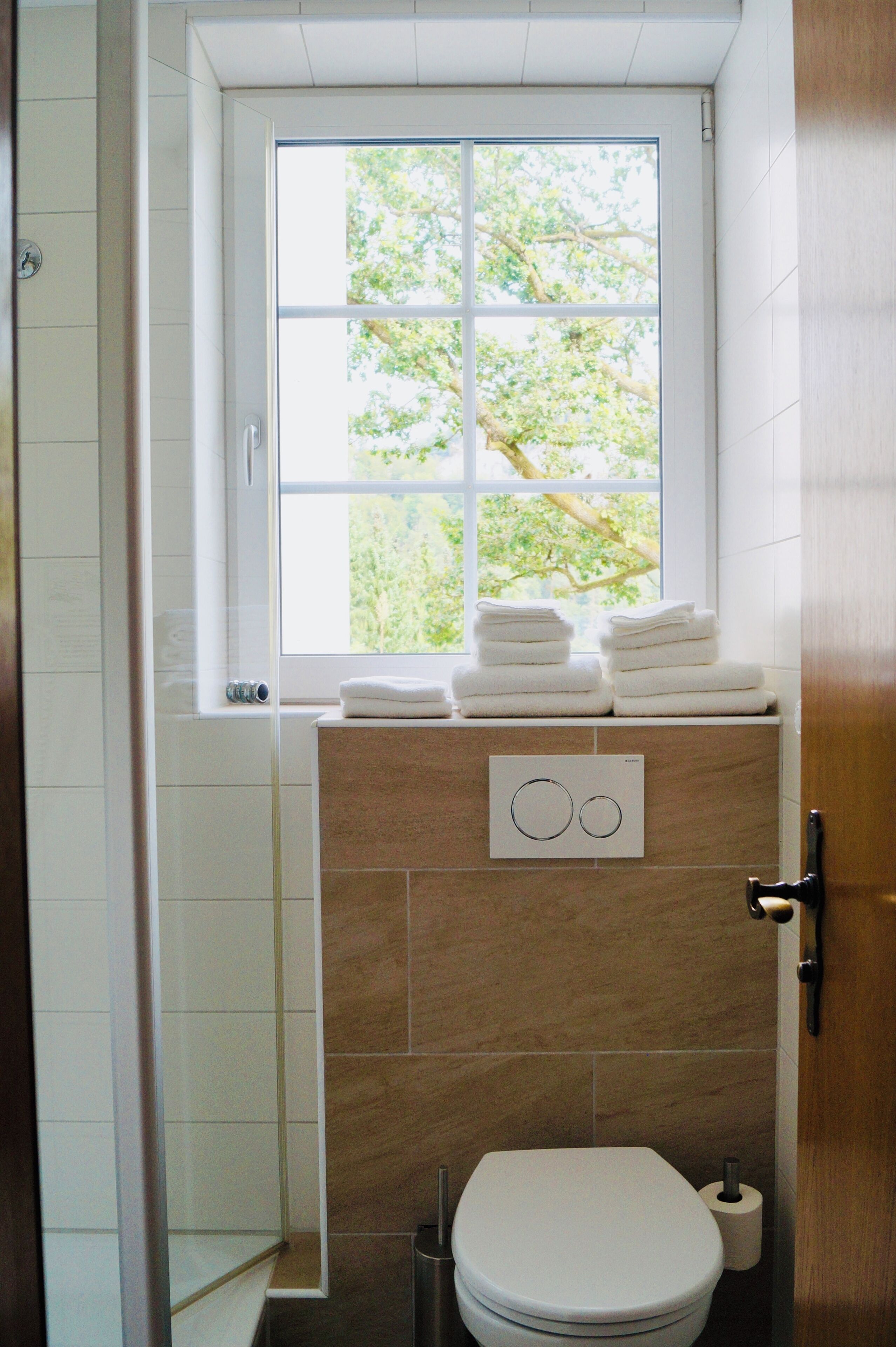 Deluxe tweepersoonskamer | Badkamer | Een douche, een haardroger, handdoeken, zeep