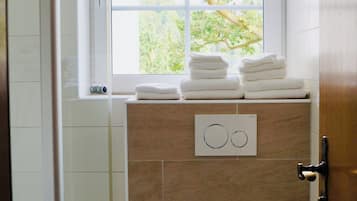 Deluxe tweepersoonskamer | Badkamer | Een douche, een haardroger, handdoeken, zeep