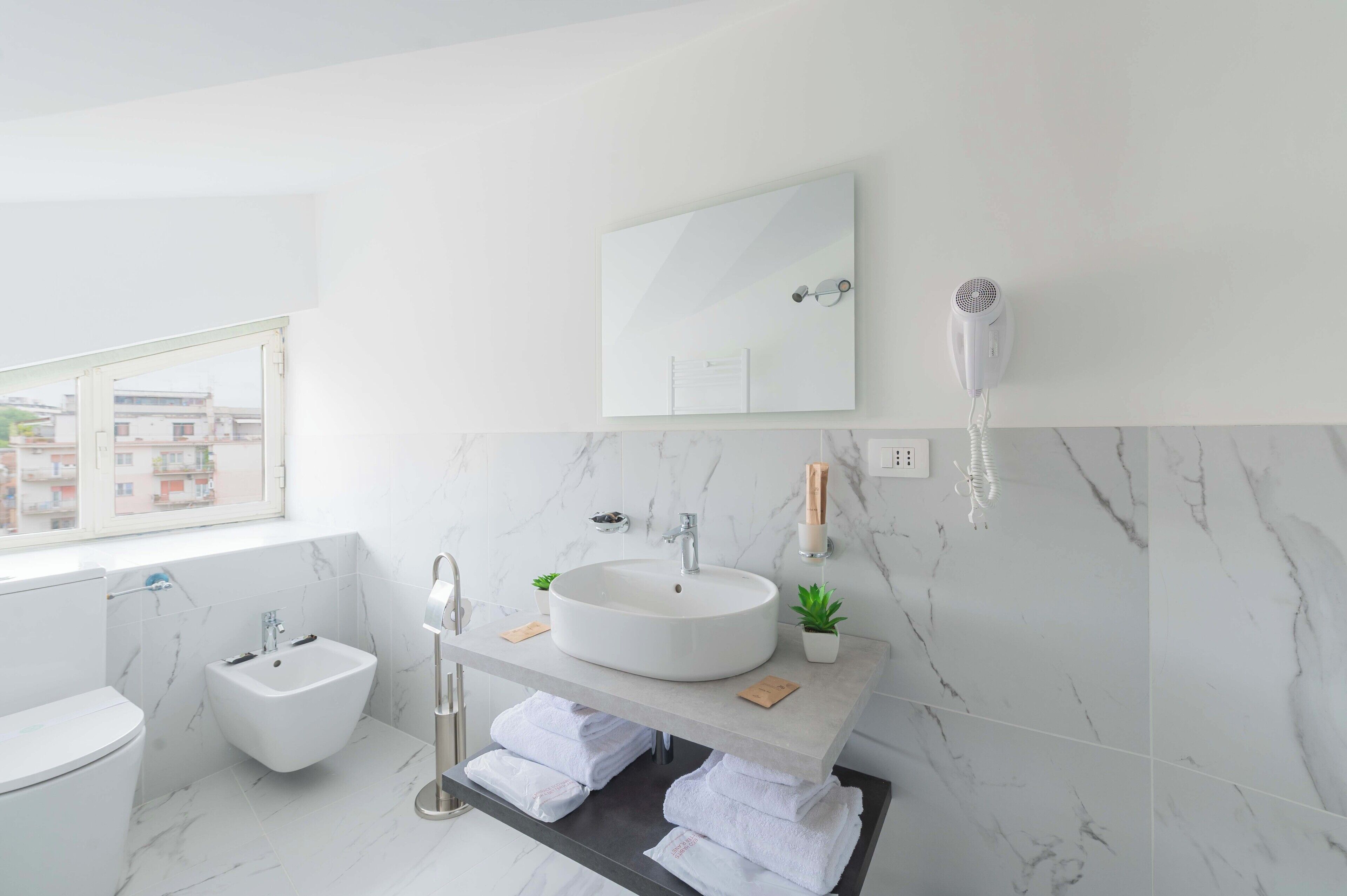 Habitación triple Deluxe | Baño | Ducha, artículos de higiene personal ecológicos y secador de pelo