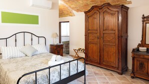 A bedroom with a bed, wooden wardrobe, and a green wall.