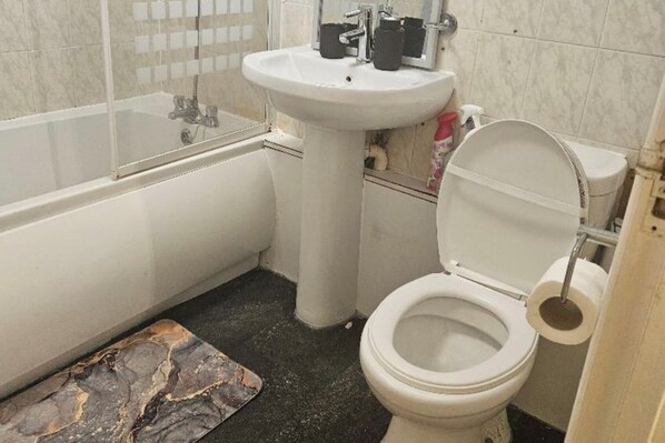 Un baño con bañera, lavabo e inodoro.