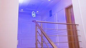 A staircase with a metal handrail leading to a room with a wooden door. - Lekki Aprt/pool/gym/sleeps 6/ Freep/tv/wifi (Lekki)