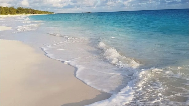 A beach with clear turquoise water and white sand.