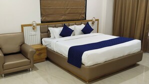 Une chambre à coucher avec un lit, une table de chevet, une chaise et une fenêtre avec des rideaux.