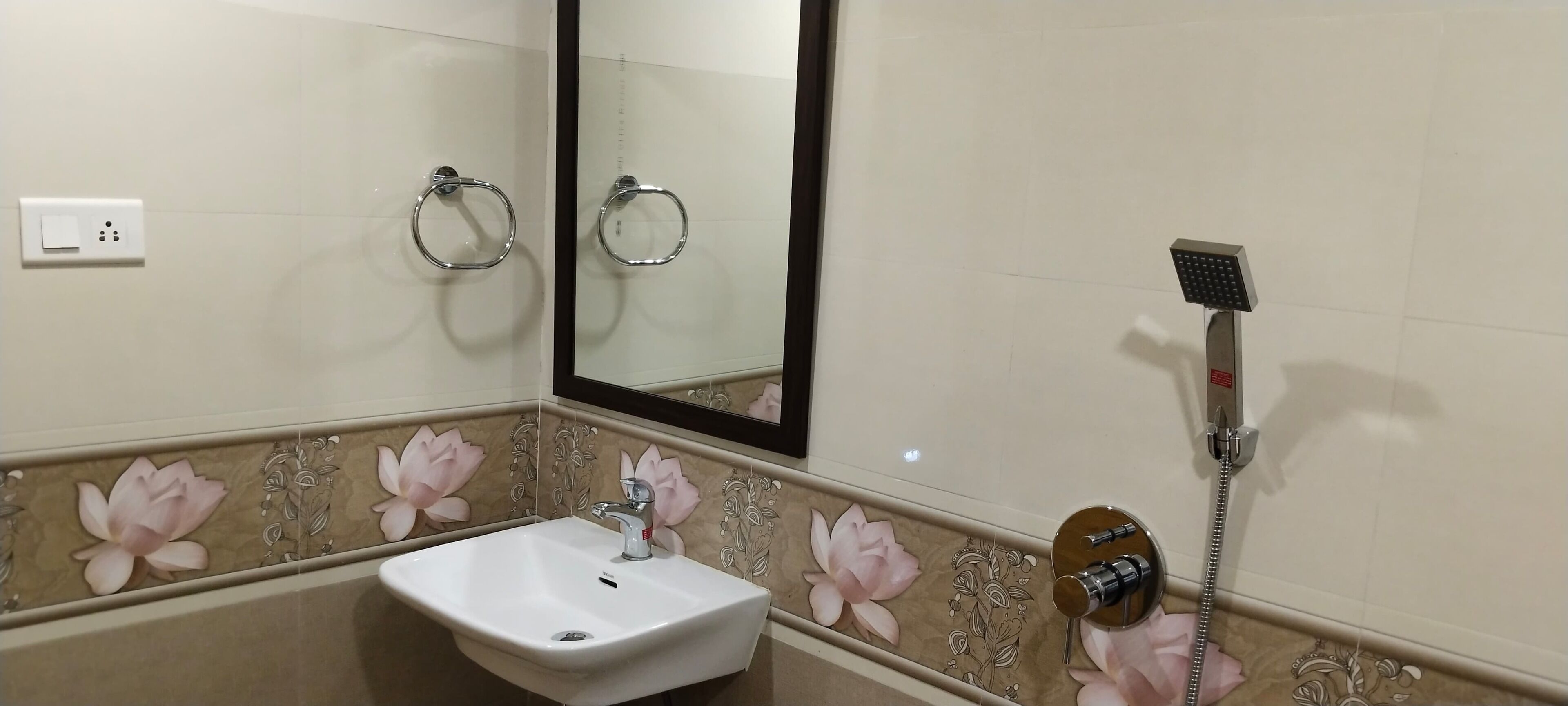 Une salle de bain avec un lavabo blanc, un miroir et une douche.