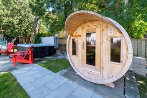 A wooden cabin with a curved roof, a patio area with red chairs, and a pool in the background. - 6 Beds Resort Vibes| Hot Tub + Dry Sauna | BIG FAMILY HOME | sleep 15 (Richmond Hill)