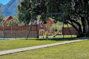 Relax in a family-friendly outdoor space with a swing set and a paved walkway.