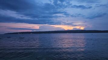 A coastal view with calm waters reflecting the sky.