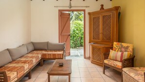 Ein gemütlicher Wohnbereich mit einer Couch, einem Holztisch und einem Sessel.