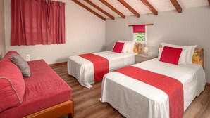 A room with two beds, each with red and white bedding, a wooden bench, and a window with a view of greenery. - Villa Muscade - Maison avec piscine partagée (Saint-Francois)