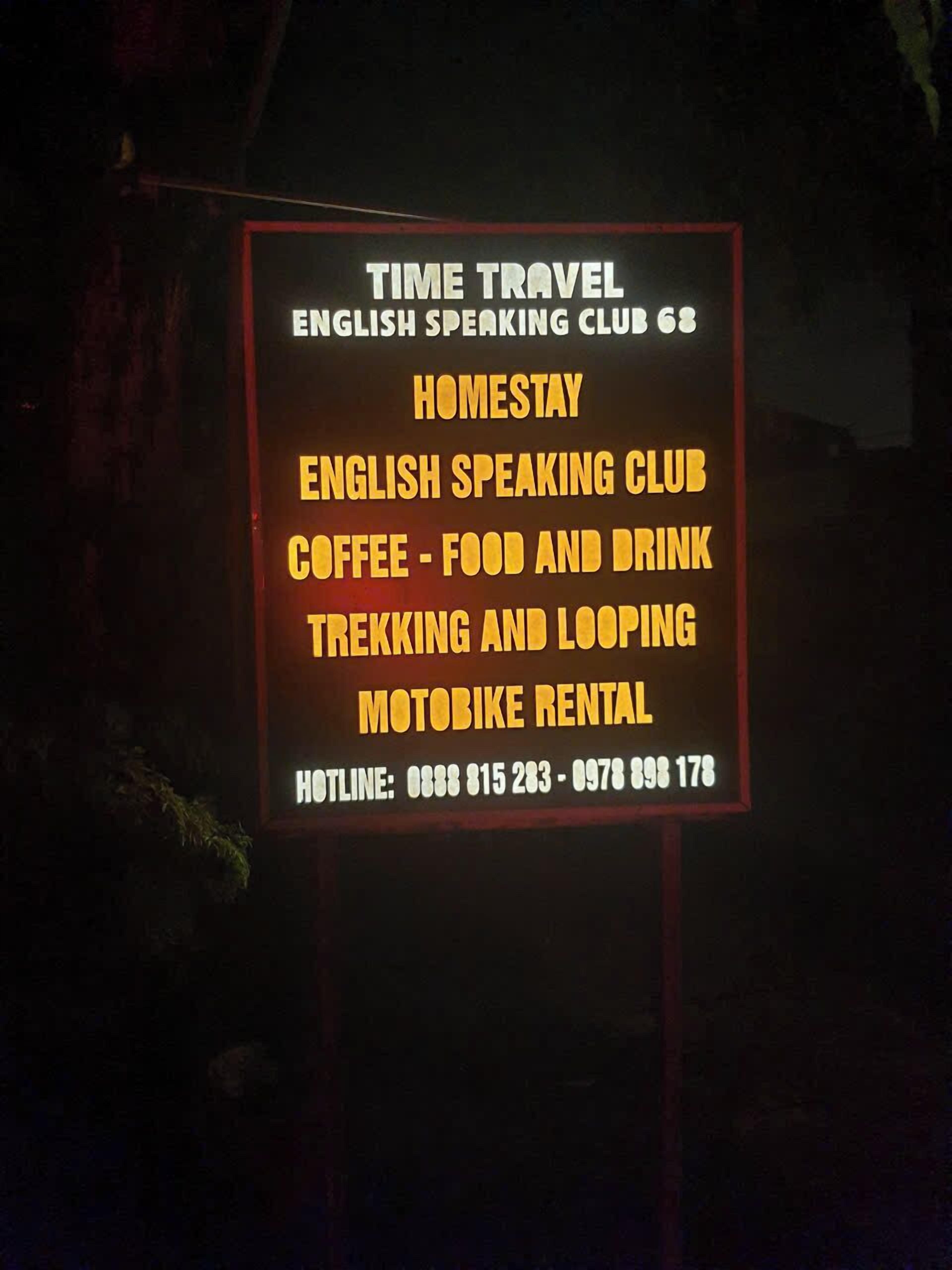 A sign listing amenities including an English Speaking Club, Homestay, Coffee, Food and Drink, Trekking and Looping, and Motobike Rental.