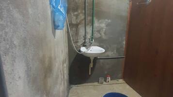 A small bathroom with a white sink, a blue basin, and a toilet.