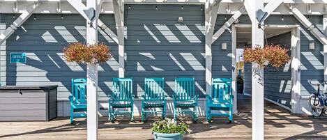 A porch with blue chairs and a planter.