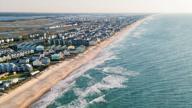 An aerial view of a coastal residential area with houses along the beachfront. - Loggerhead Inn & Suites - Two Queen Suite in hotel in Surf City, North Carolina (Surf City)