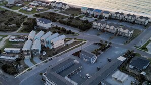 An aerial view of a coastal residential area with houses, a parking lot, and a road. - Loggerhead Inn & Suites - Two Queen Suite in hotel in Surf City, North Carolina (Surf City)