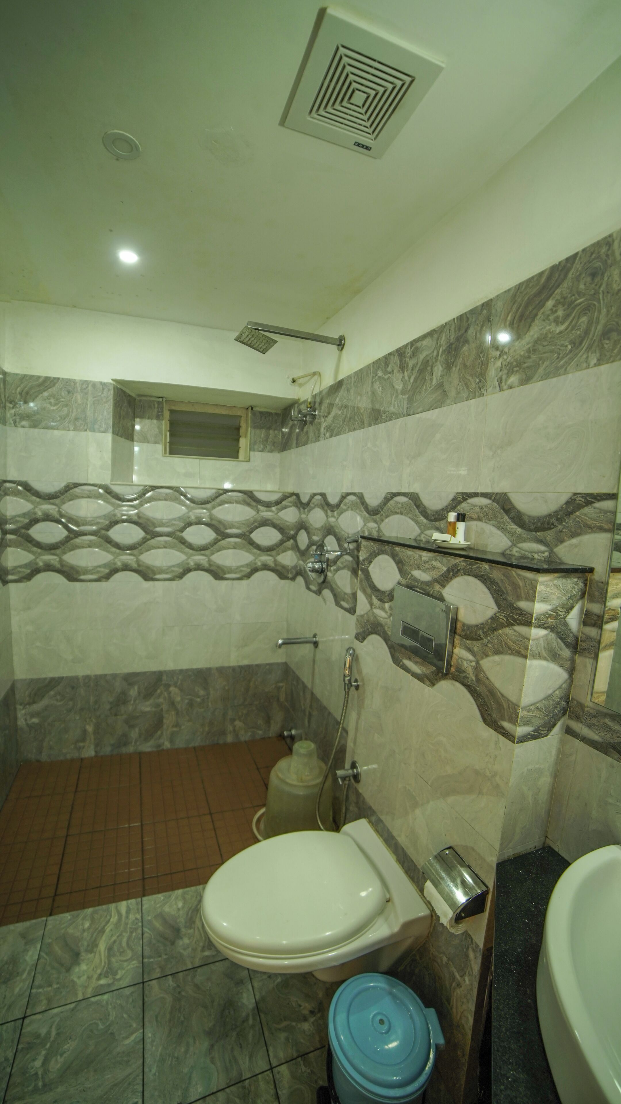 A bathroom with a toilet, shower, and sink.