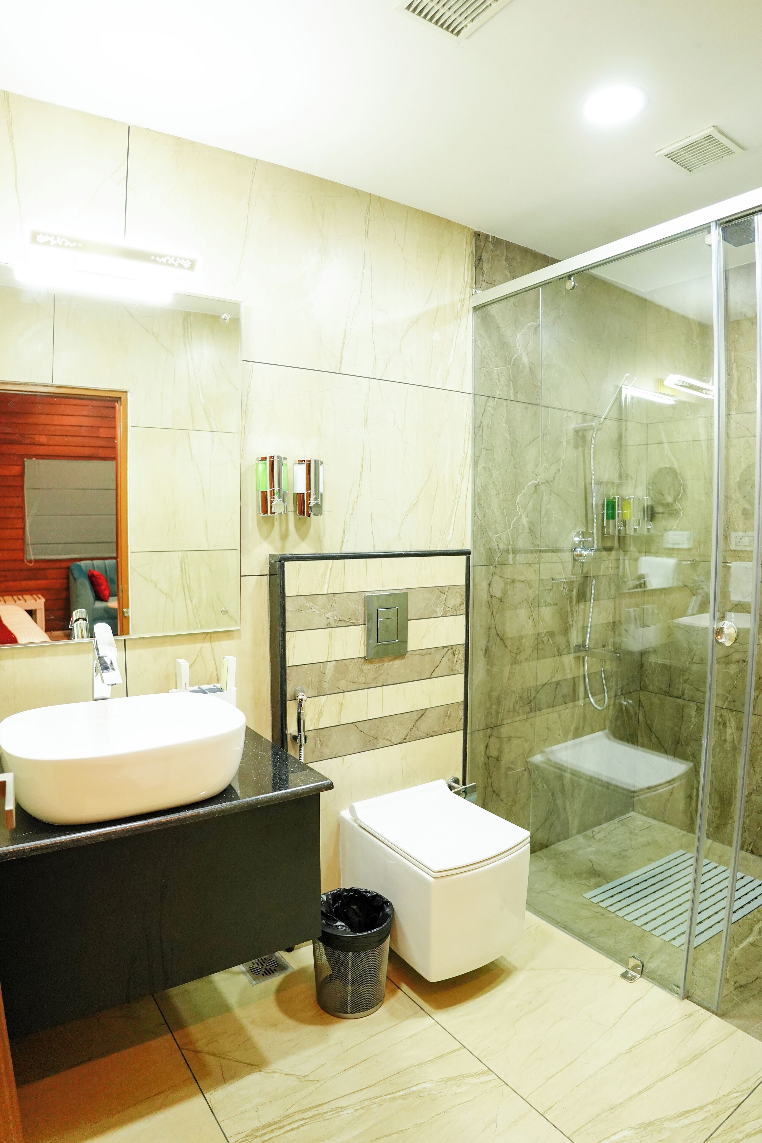 A modern bathroom with a large sink, toilet, and glass-enclosed shower.