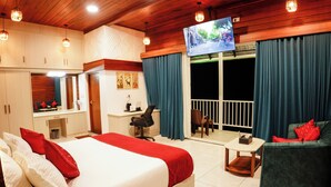 A hotel room with a bed, a desk, a chair, a TV, and a balcony with curtains. - Mount Valley Resort - A Secluded Getaway (Devikolam)
