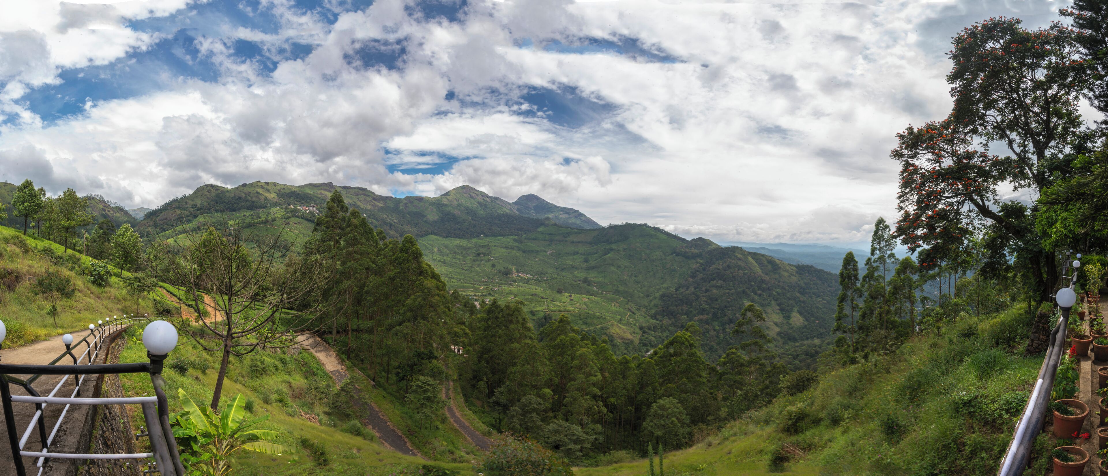Um vale verdejante e exuberante, com céu limpo e montanhas ao longe.
