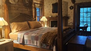 Un dormitorio acogedor con una cama de madera, una chimenea y vistas al exterior.