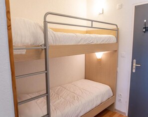 Ein Etagenbett mit Holz-Kopfteil und einer Wandleuchte.